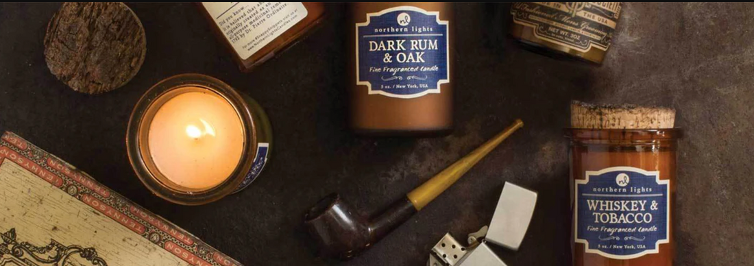 Candle, pipe, and bottles of whiskey on a textured surface